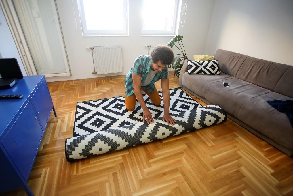 man unfolding the carpet